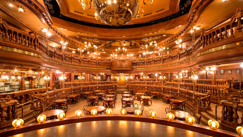Mesa ambientada en The lucky nugget saloon, rodeada por una decoración western meticulosa y luces suaves que iluminan el espacio.