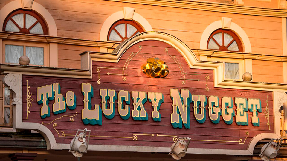 Cartel dorado y brillante de The lucky nugget saloon.